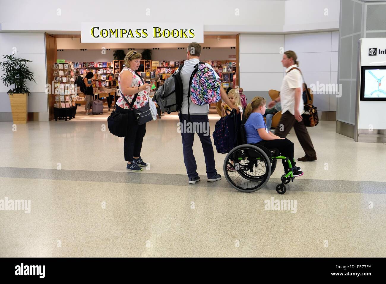 Familie, darunter ein Kind im Rollstuhl, reist gemeinsam am San Francisco International Airport in San Francisco, Kalifornien, USA. Stockfoto