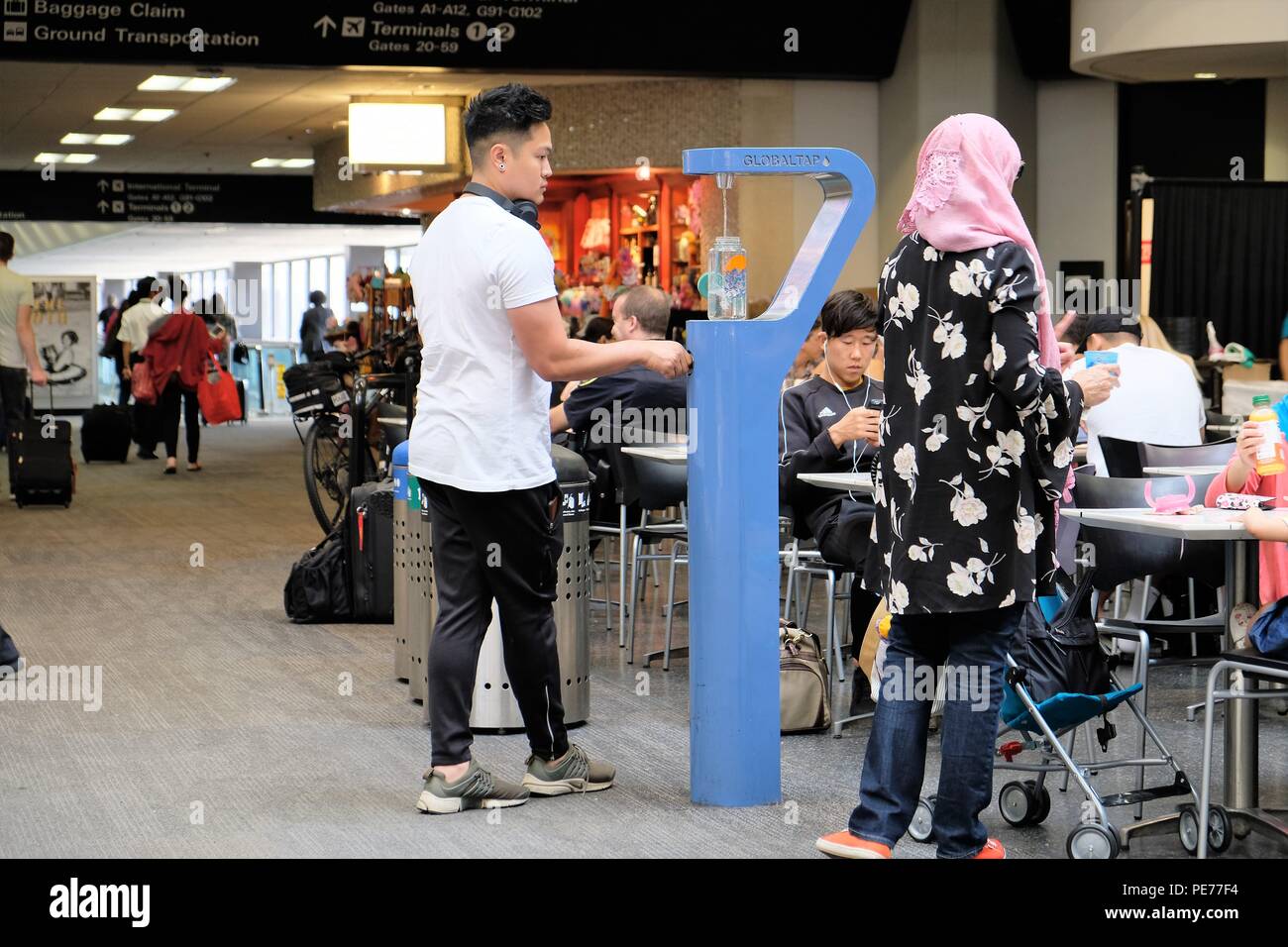 Männlichen reisenden Füllen einer Wasserflasche an eine Hydratation Station am Flughafen San Francisco International, San Francisco, Kalifornien, USA. Stockfoto