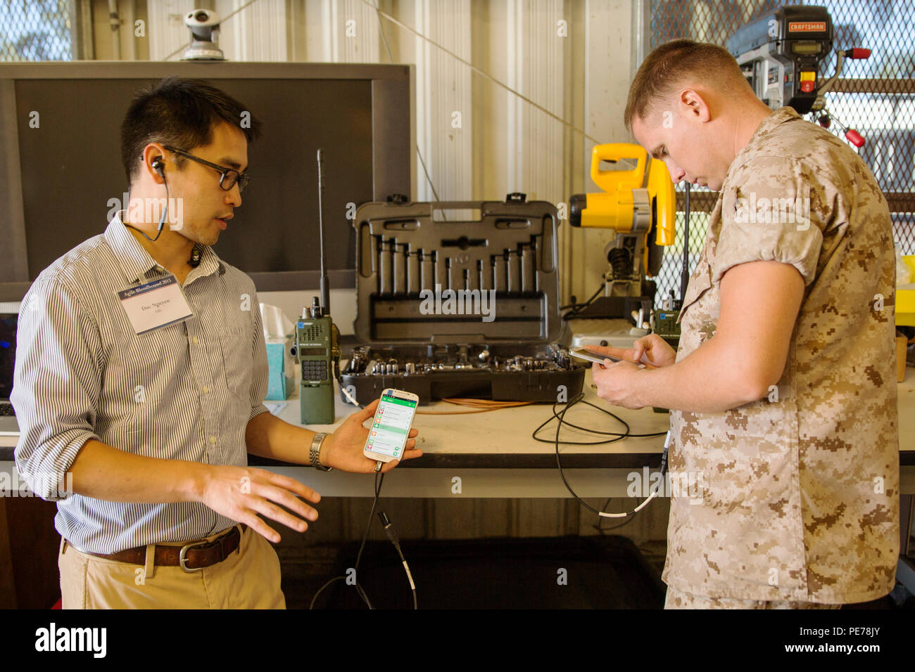 Duc Nguyen, ein Software-ingenieur aus dem Naval Research Laboratories, Arlington, Va., erklärt Cpl. Christopher Griffen, vom 4 Force Reconnaissance, 4 Marine Division, wie die Kommunikation zwischen serverlosen Chat auf zwei Android Smartphones' Funktionen während der Agile Bloodhound Demonstration 2015 an Bord der Marine Corps Base Hawaii, Okt. 29, 2015. Agile Bloodhound war 15 Okt. 19 durchgeführt - 29 MCBH zu Forschung und Entwicklung und die damit verbundenen Technologien, die die Auslandseinsätze warfighter Unterstützung hervorheben. Teil von AB 15 war die Verwendung von kleinen Einheit Entscheidungshilfen (SUDA), das es erlaubt, Stockfoto