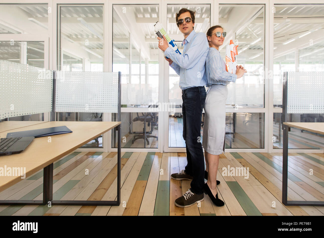 Lachend Mitarbeiter mit Spielzeugpistolen im Büro Stockfoto