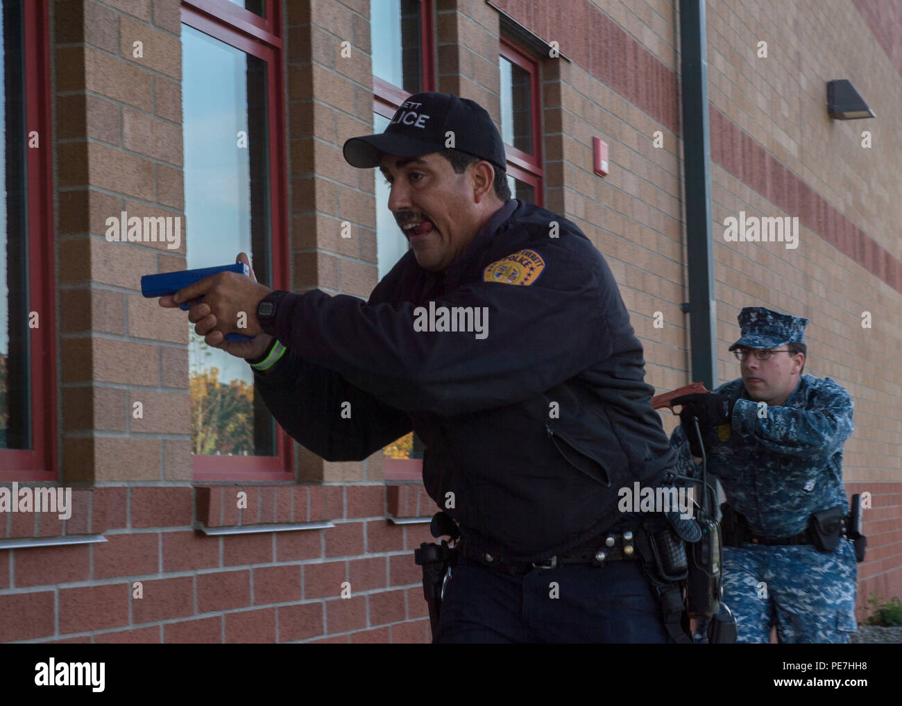 151057-N-LQ 926-141 Everett, Washington (Okt. 15, 2015) - Officer Mike Bernardi, mit der Everett Polizei-abteilung, und Master-at-Arms 2. Klasse Blake C. Denton, die Naval Station Everett, Durchführung Zimmer clearing Taktiken auf Basis während der aktiven Shooter übung Reliant Verteidigung. Reliant Verteidigung ist für Marine und Notfallstelle, Bereitschaft, bevor sie eine tatsächliche Not- oder Katastrophenfall zu verbessern. Naval Station Everett ist auf die Zusammenarbeit mit lokalen Behörden der Gemeinschaft für die Reaktion und die Wiederherstellung ein Betrieb in Zeiten der Krise verpflichtet. (U.S. Marine Foto von Mass Communication Specialist 2. Klasse Ale Stockfoto