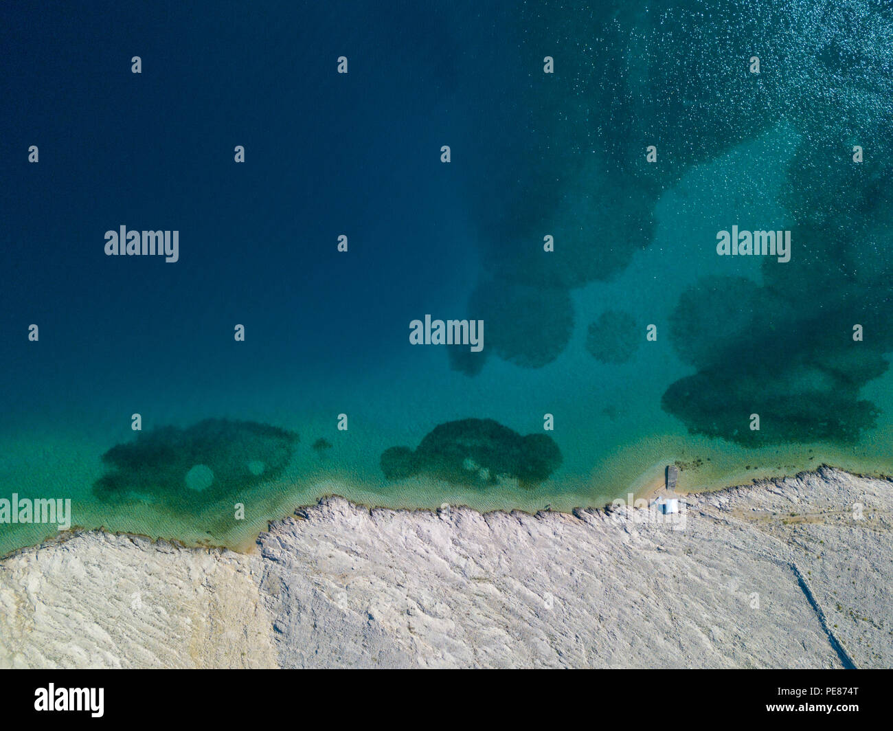 Luftaufnahme von einer trendigen Zelt, Brief aus der Sonne. Felsen am Meer und transparenten Meer Stock. Entspannen und Urlaub unter einem weißen Zelt von Felsen umgeben Stockfoto