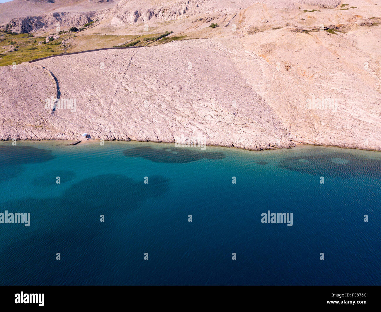 Luftaufnahme von einer trendigen Zelt, Brief aus der Sonne. Felsen am Meer und transparenten Meer Stock. Entspannen und Urlaub unter einem weißen Zelt von Felsen umgeben Stockfoto