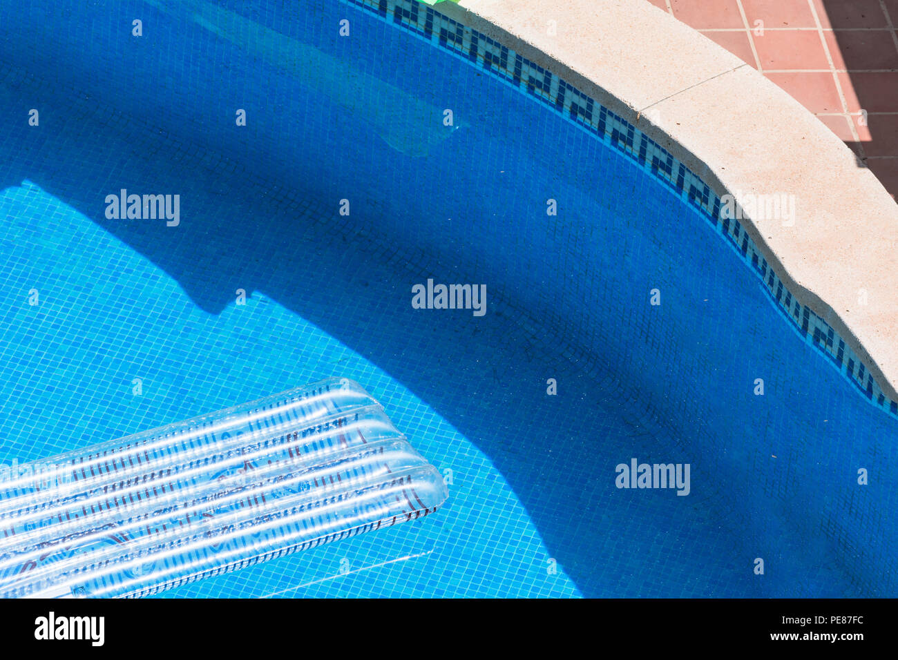 Durchsichtige Luft Matratze schwimmt in einem blauen Pool. Stockfoto