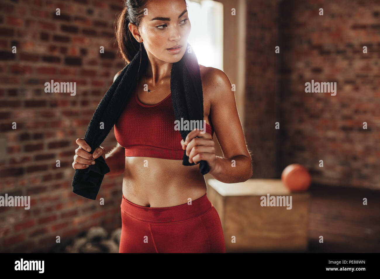 Passen junge Frau mit einem Handtuch im Health Club. Weibliche Entspannung nach dem Training. Stockfoto