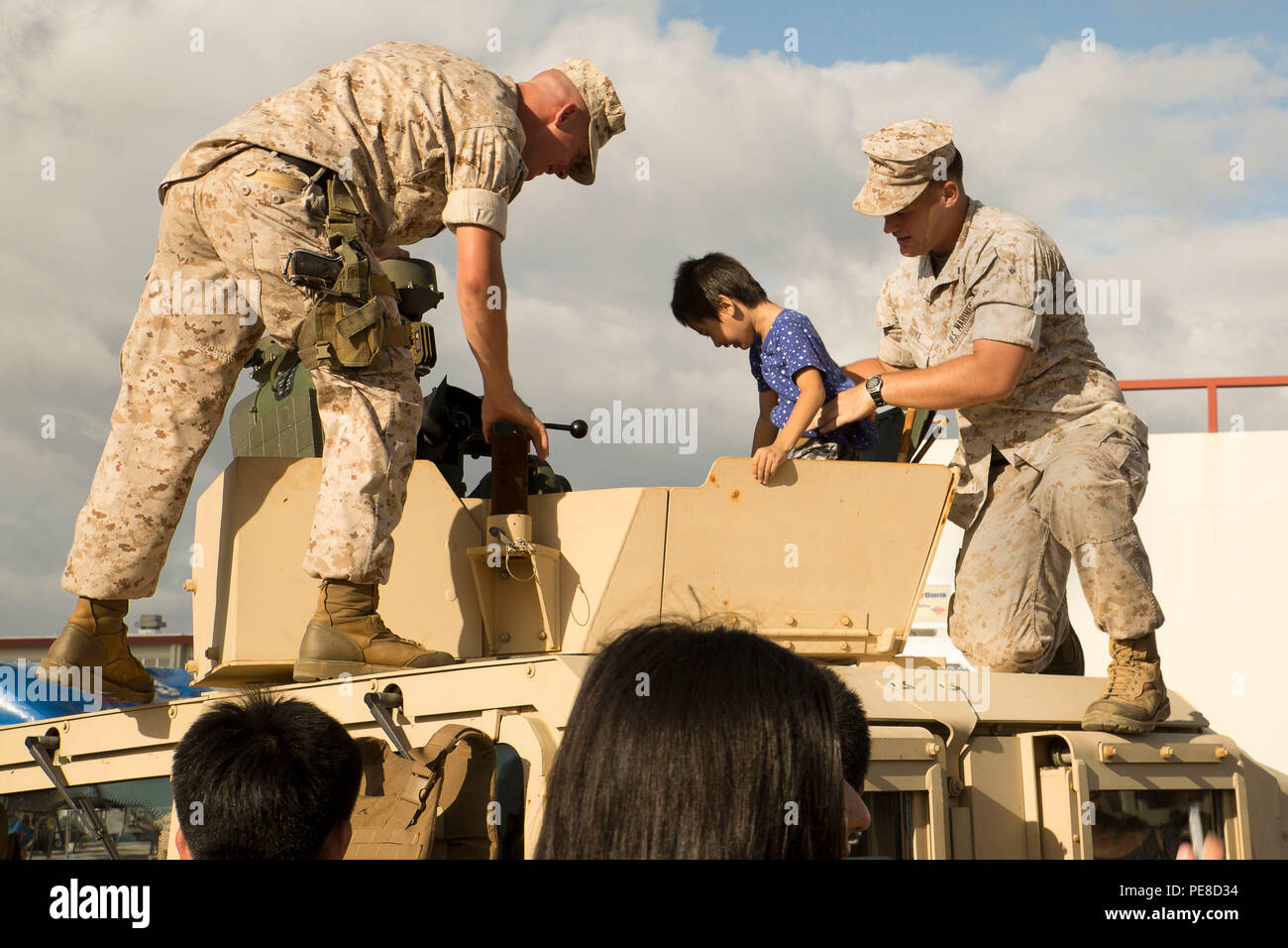 Marines Hilfe ein Kind klettern aus einem Humvee auf dem Display während Kinser Festival Okt. 24 an Bord Camp Kinser, Okinawa, Japan. Das Festival war ein zwei Tages, open-gate Ereignis am Okt. 24 und 25 angeboten, so dass die Einwohner von Okinawa zu besuchen. Die Besucher wurden aufgefordert, über und erkunden Sie die verschiedenen militärischen Ausrüstung auf Anzeige lernen. Stockfoto