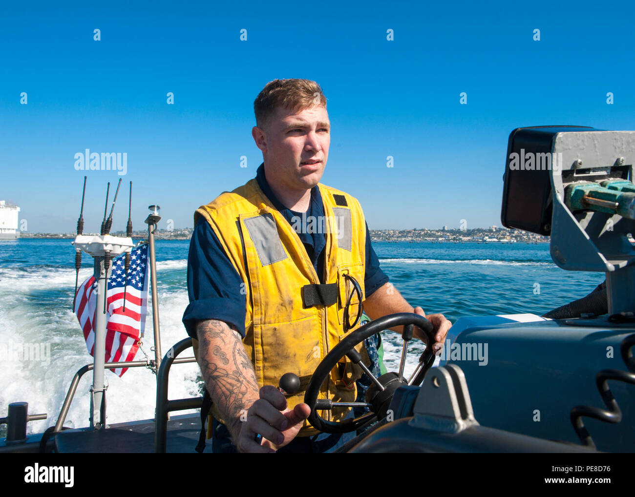 A Boatswain’s Mate 2nd Class navigiert am 22. Oktober 2015 in der Nähe der USS Carl Vinson (CVN 70) in der San Diego Bay auf einem Schlauchboot mit starrem Rumpf (RHIB). Der Flugzeugträger der Nimitz-Klasse befindet sich in einer Wartungsperiode des Chief of Naval Operations Planned Incremental Availability am Homeport von San Diego. Die RHIB unterstützt den Schiffsbetrieb, den Personentransport und das Manövrieren im Hafen, während die Sicherheit und Bereitschaft der Streikgruppen der Frachtführer gewahrt bleibt. Stockfoto