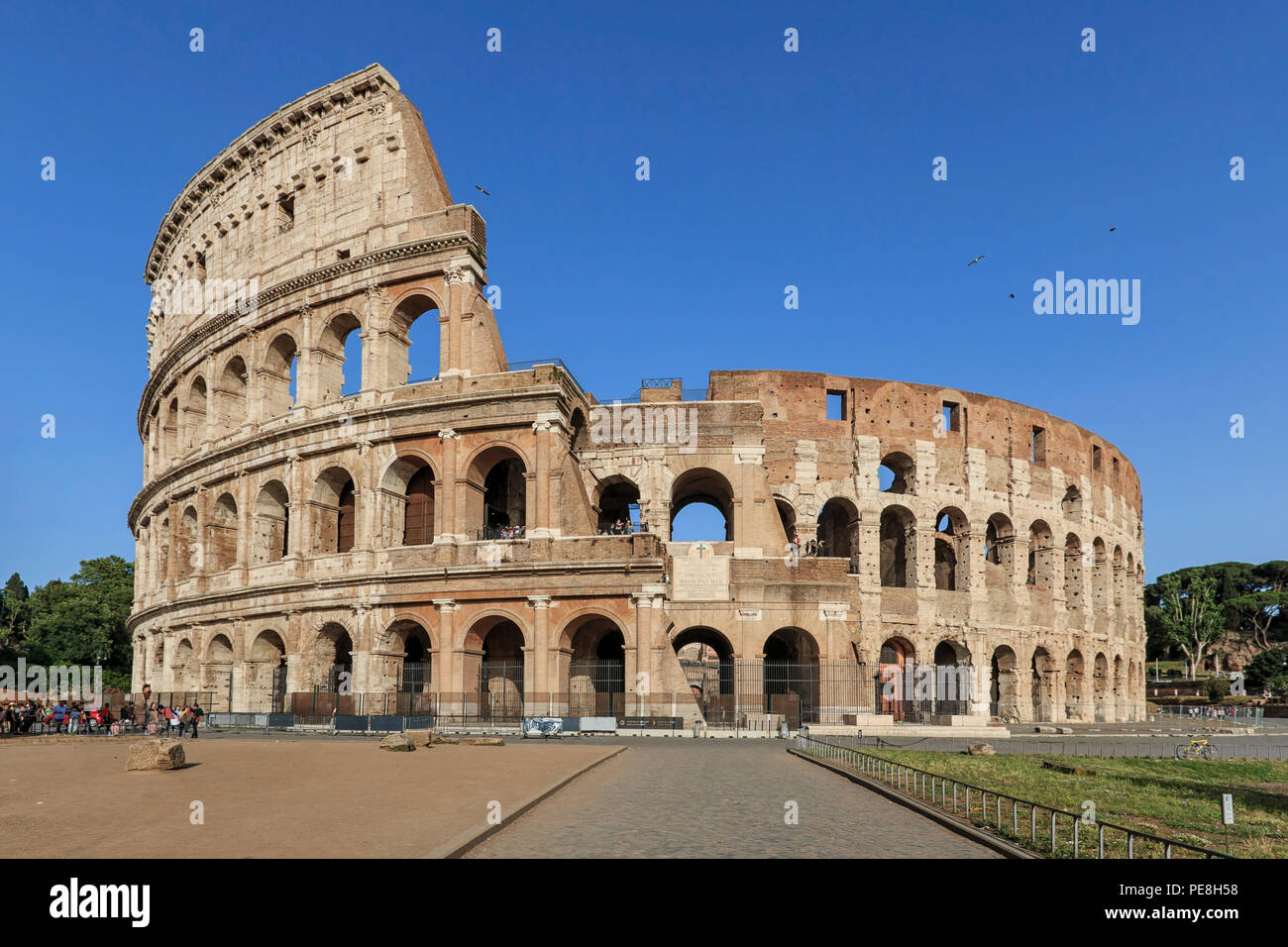 Rom, Italien, 11. Juni 2018: Kolosseum an einem sonnigen Tag in Rom, Italien, mit einer kleinen Gruppe von Touristen Stockfoto