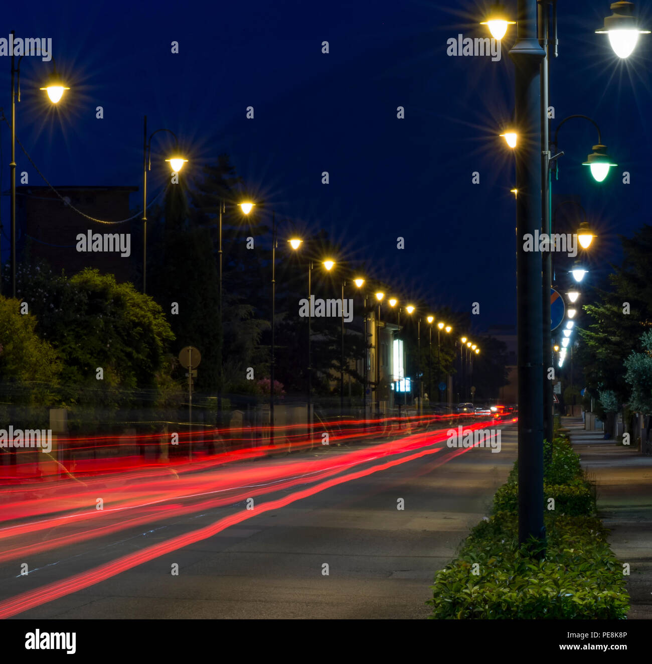 Avenue mit leichten Spuren von Autos, die in der blauen Stunde Stockfoto