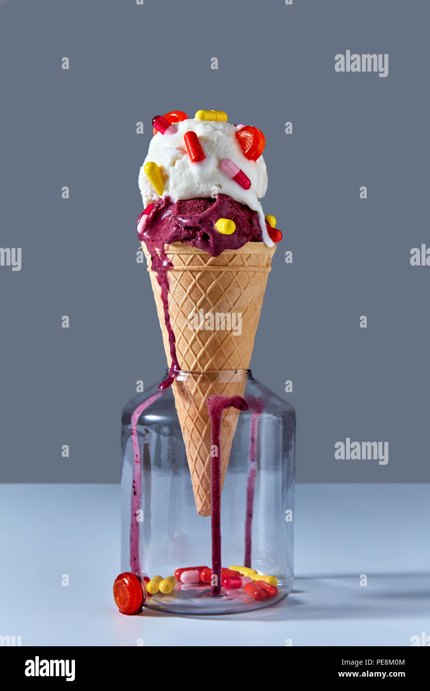 Die Waffel Kegel Mit Einem Kalten Eis Steht In Glas Glas Mit Roten Und  Gelben Kapseln Und Einen Lutscher. Jar Auf Grauem Hintergrund. Pils Und  Lutscher In Einem Jar Stockfotografie - Alamy