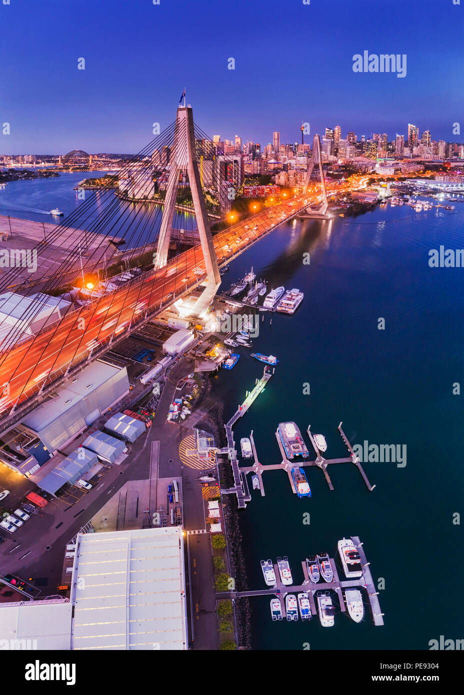Stadt Sydney ANZAC Bridge am Hafen während der Blauen Stunde in Antenne erhöhten Blick auf City Marina in Richtung CBD Türme mit helle Beleuchtung. Stockfoto