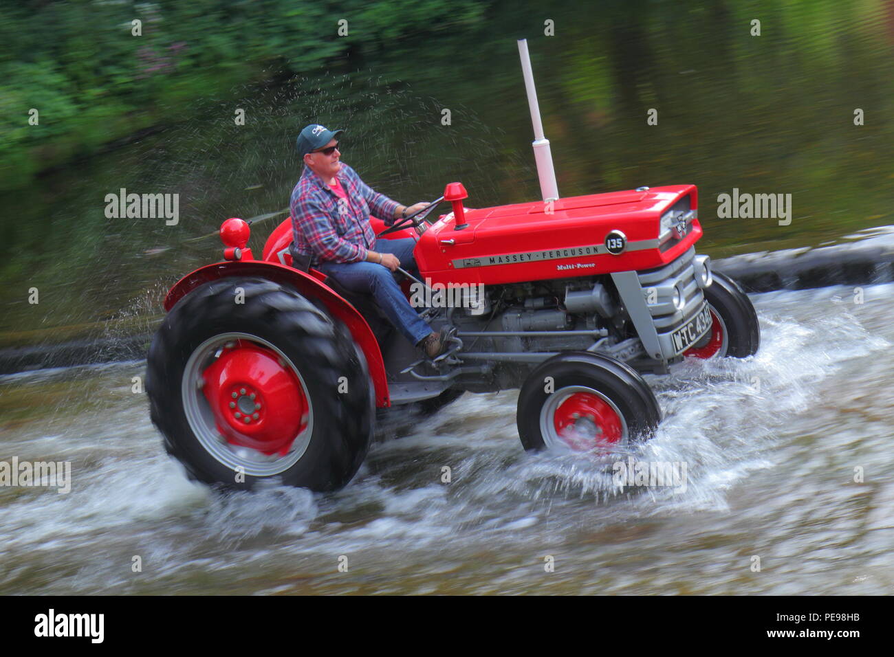 Eine rote Massey Ferguson Traktoren den Fluss Skell Ford Kreuzung in Ripon, North Yorkshire Stockfoto