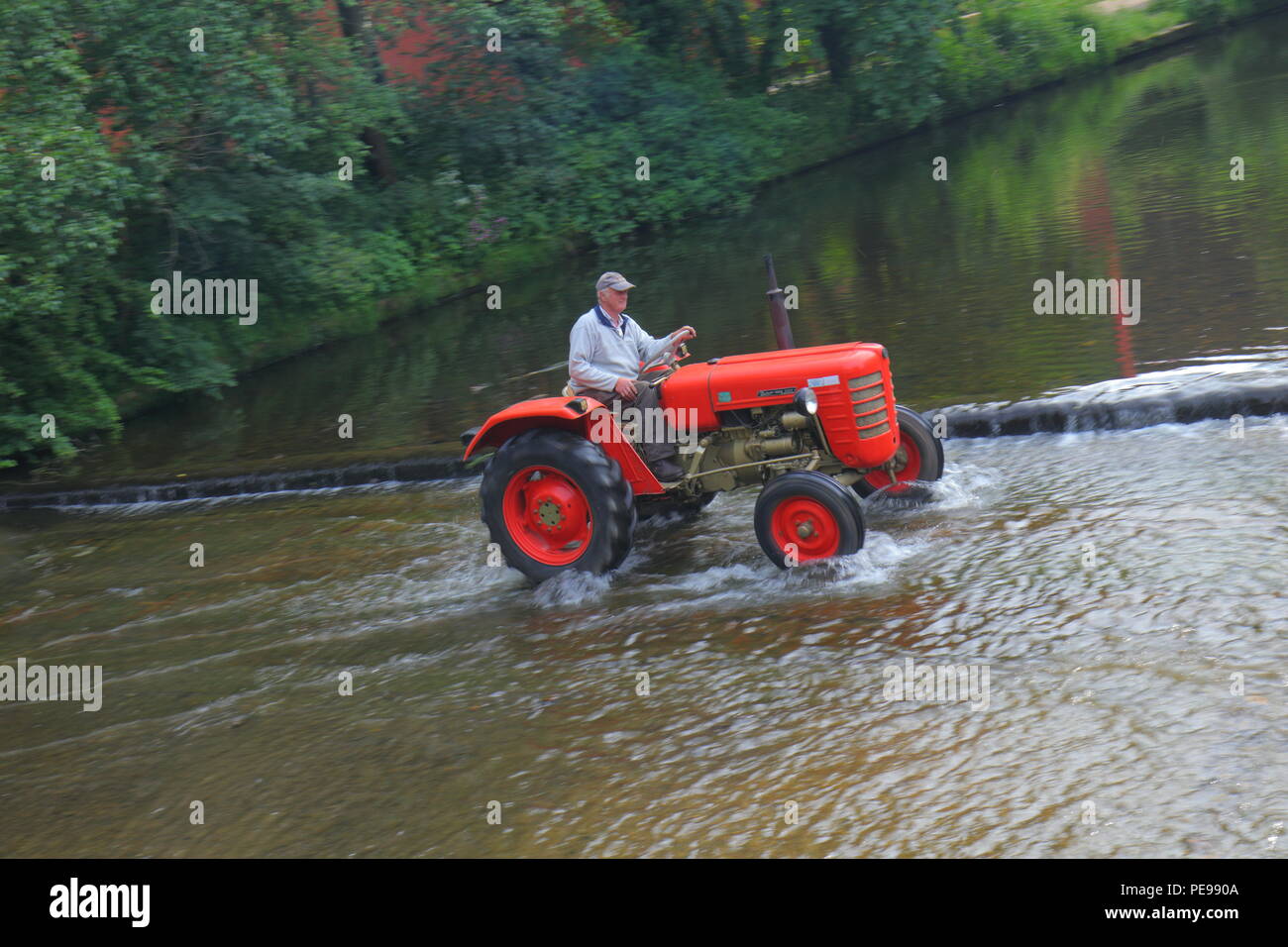 Ein Traktor der Überquerung des Flusses Skell in Ripon Stockfoto