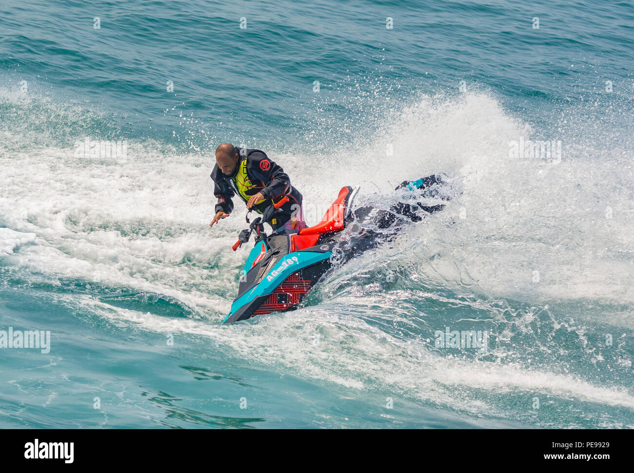 Mann fällt ein Jet Ski am Meer im Sommer in Großbritannien. Jet Ski auf dem Ozean. Fallen von Jet Skis. Stockfoto