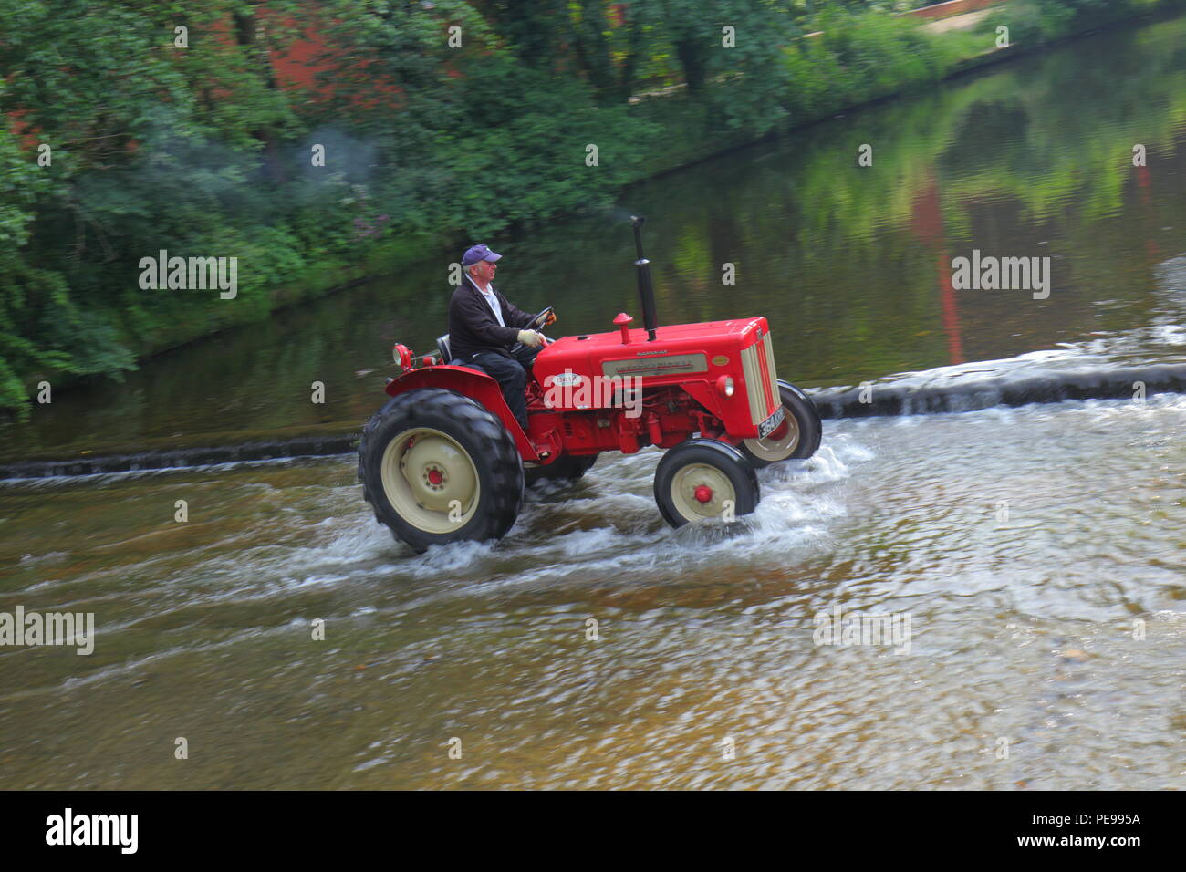 McCormick International B 414 Traktor überquert den Fluss Skell in Ripon mit einem Konvoi von anderen Traktoren, die von Newby Hall Traktor Festival Stockfoto