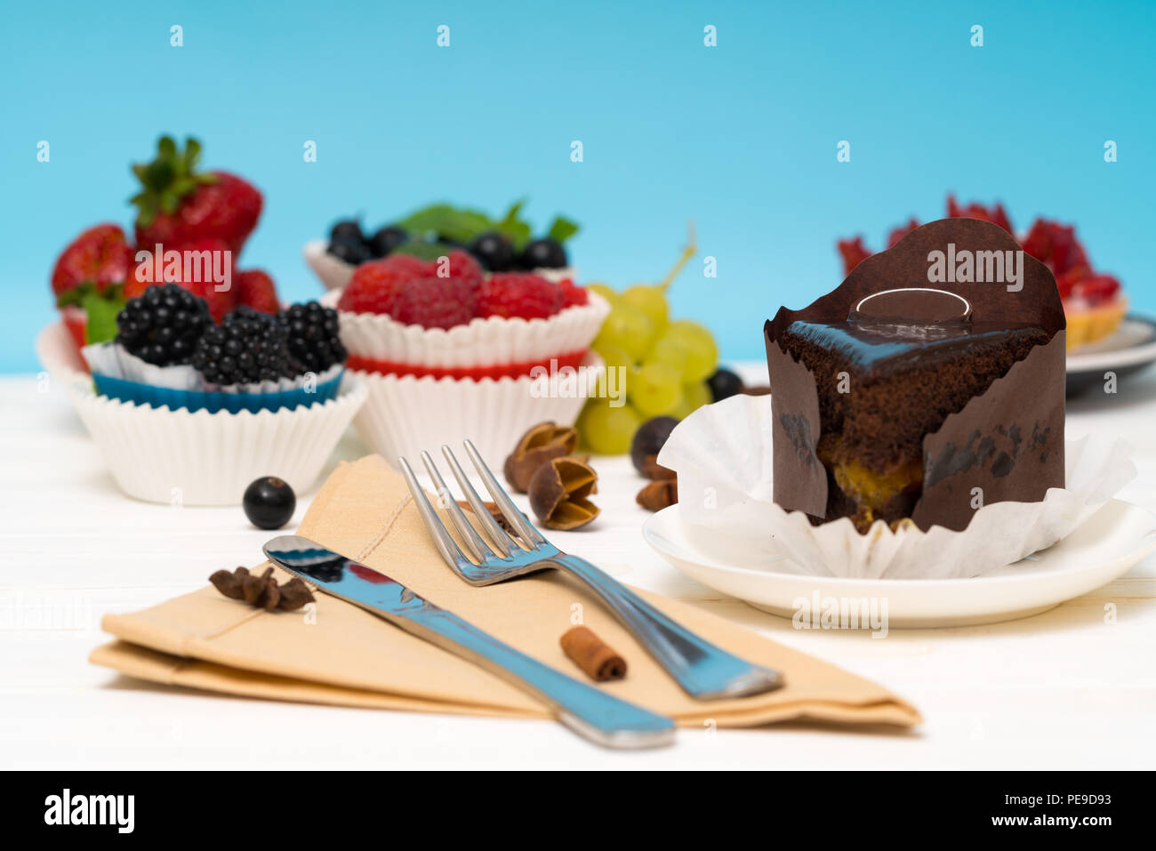 Verschiedene gourmet Desserts serviert auf einem weißen Tisch mit Schokolade Torte Kuchen und frisches Obst Kuchen mit Servietten und Besteck Stockfoto