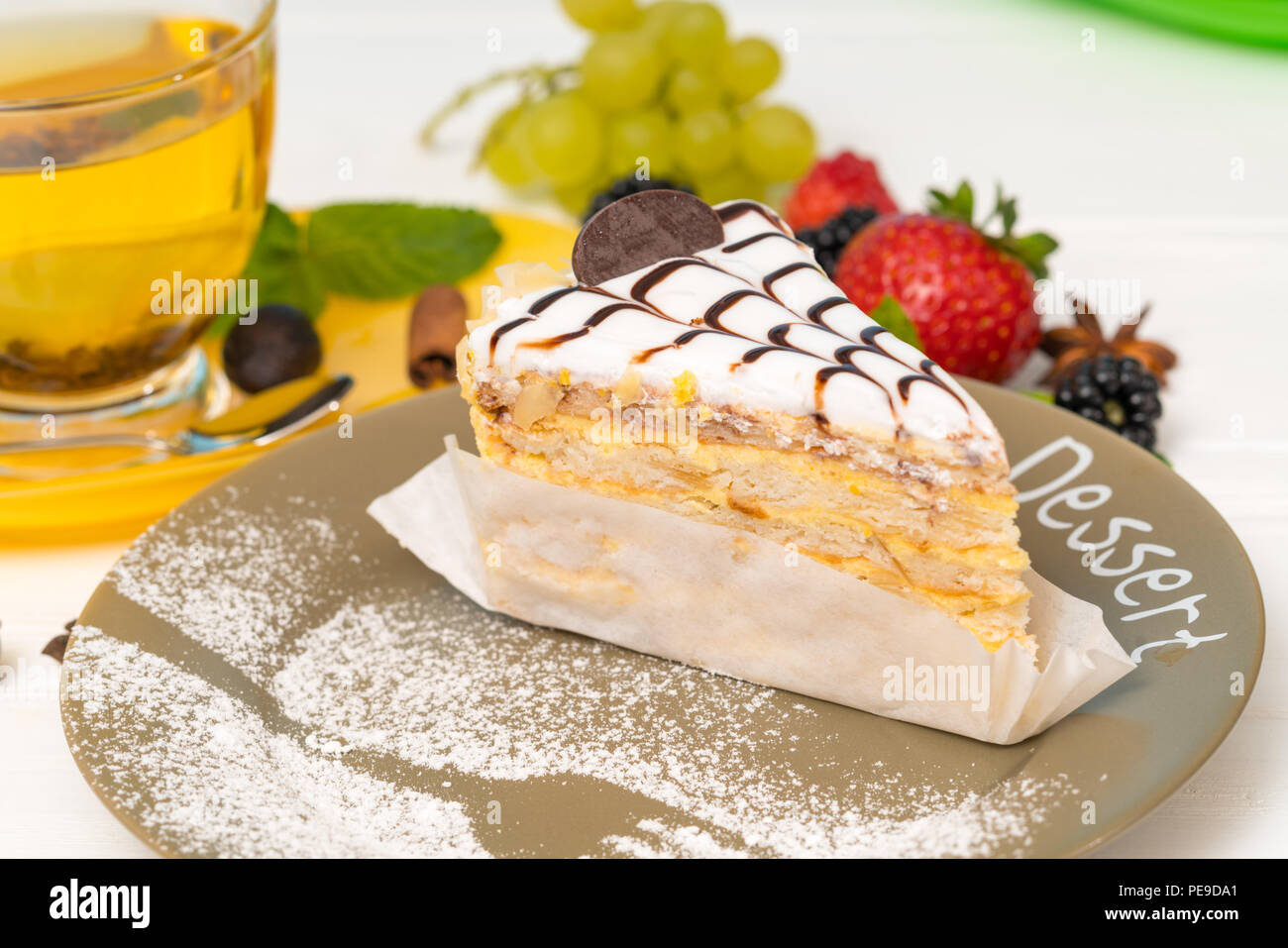 Keks Layer Cake mit dekorativen cremige Sahnehäubchen serviert auf einem Teller mit Gabel in Glasur beträufelt Zucker Stockfoto