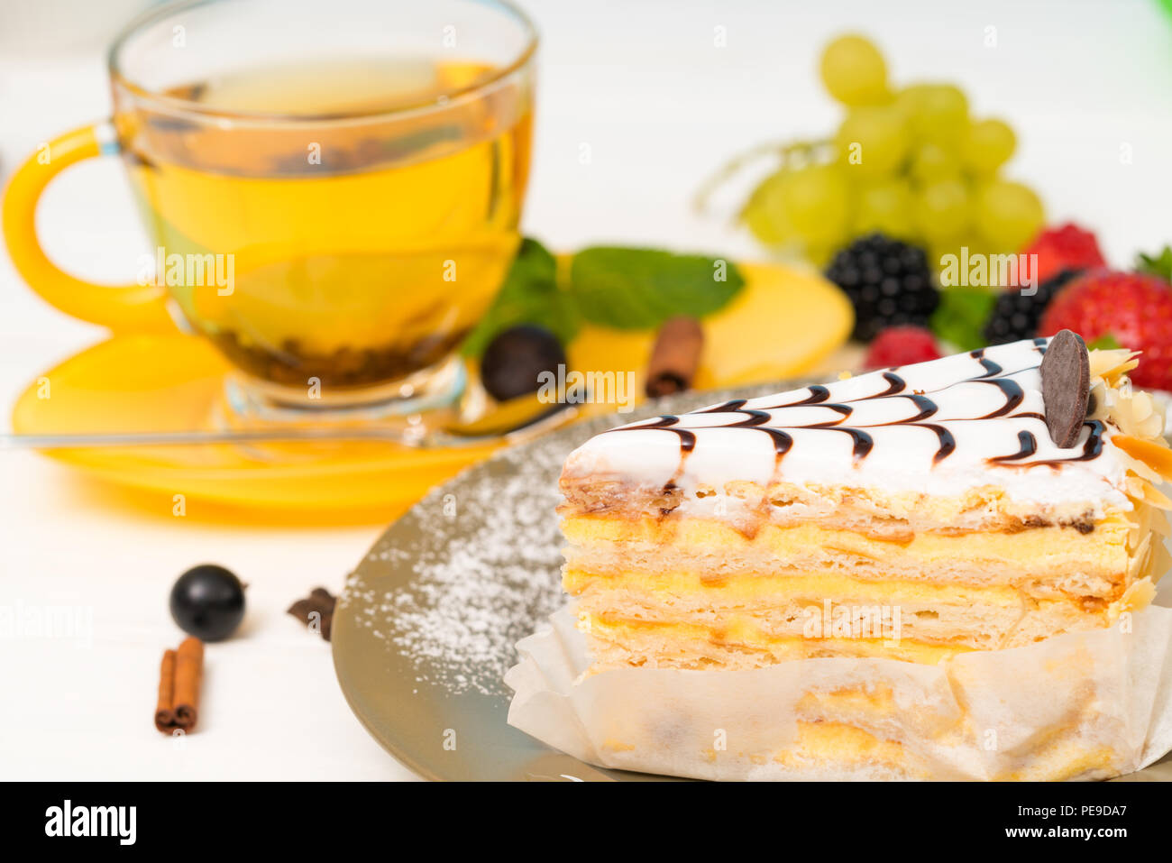 2-in-1-Keks Kuchen mit cremiger Glasur beträufelt mit Schokolade in der Nähe zu sehen, auf einer Platte mit würziger Zitrone Tee serviert Stockfoto