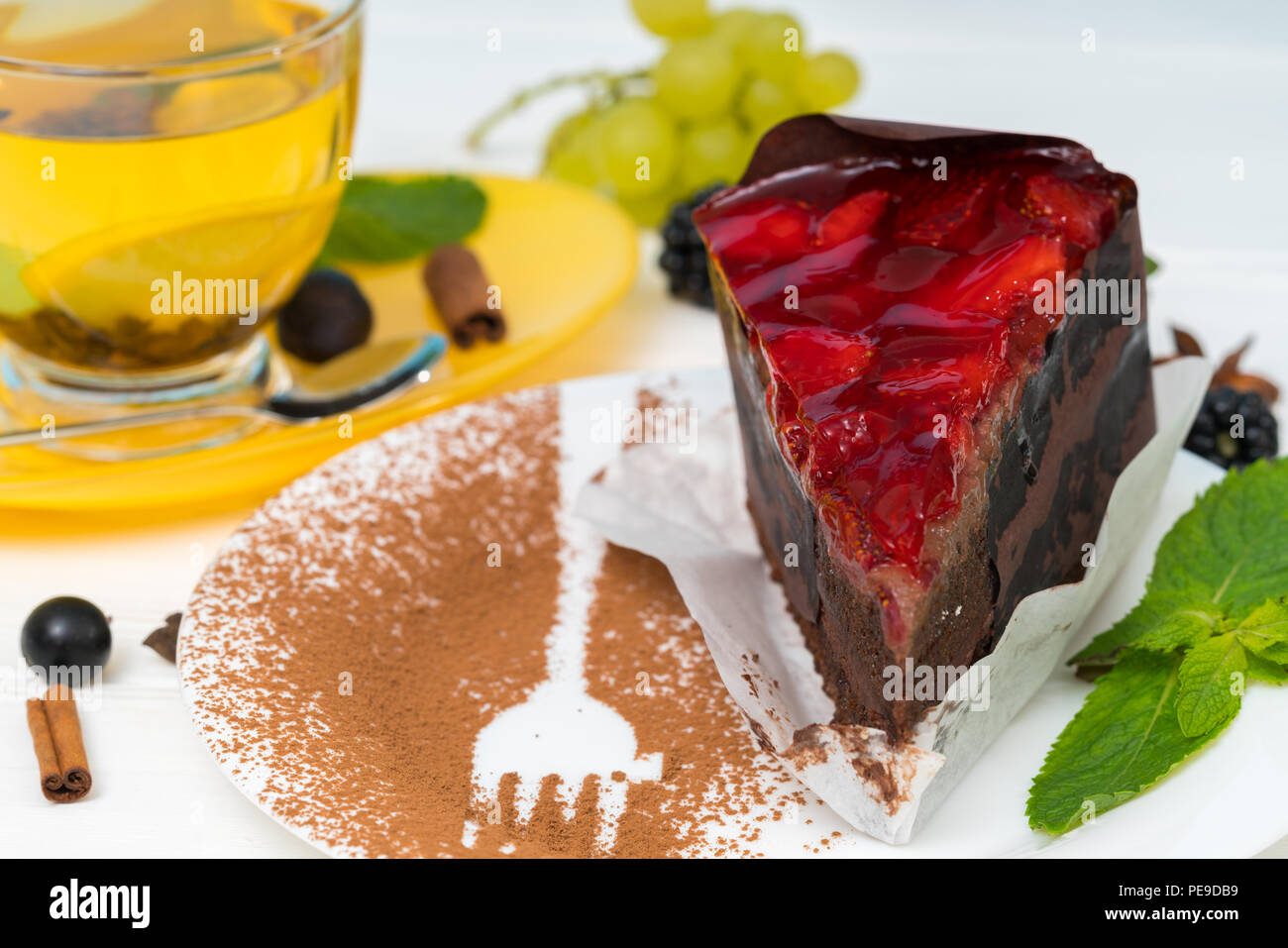 Gourmet Schokolade Kuchen Gekront Mit Erdbeeren Auf Einem Teller Mit Kakaopulver Bestreuen Und Gabel Serviert Umrisse Neben Einer Tasse Heisse Zitrone Tee Stockfotografie Alamy