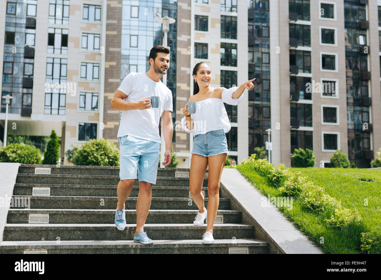 Positive freudige Frau zeigt mit dem Finger Stockfoto