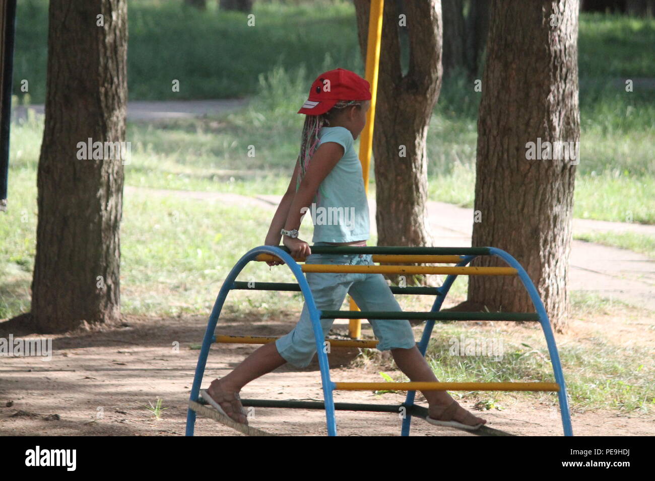 Schöne vivid Girl in Red Hat mit bunten Bändern im Haar Tanz auf dem Spielplatz im Sommer Urlaub Stockfoto