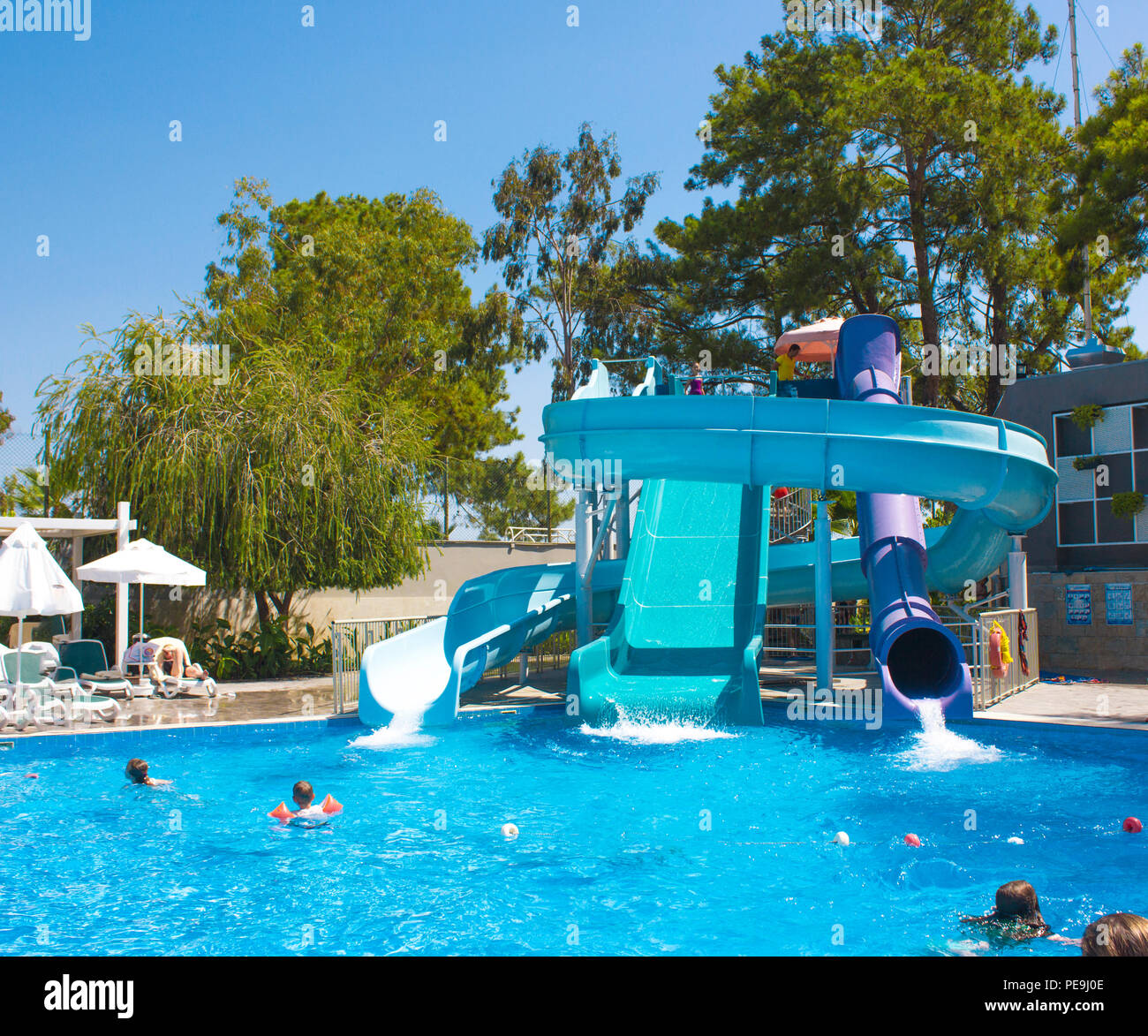 KEMER, Antalya, Türkei - 19 Juli, 2018: großer Pool mit Wasserrutschen im Barut Hotel mit einem Menschen unter blauem Himmel Stockfoto