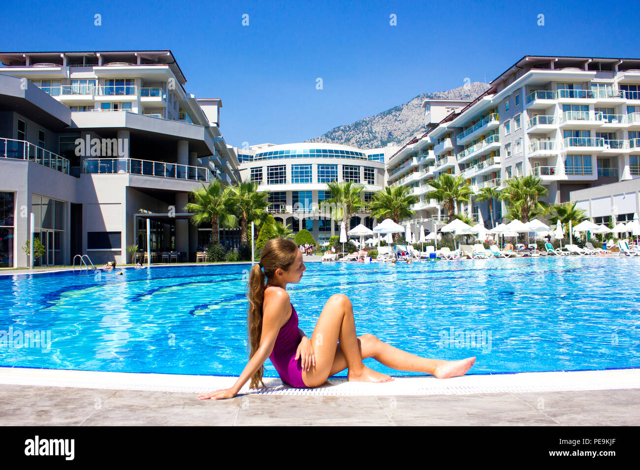 KEMER, Antalya, Türkei - 19 Juli, 2018: Schöne Mädchen im Teenageralter in  der lila Badeanzug am Pool sitzen Stockfotografie - Alamy