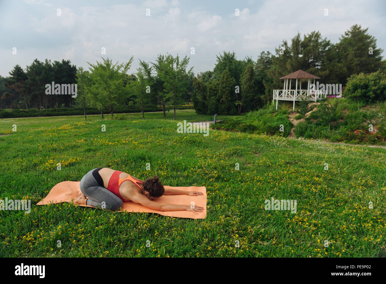 Gesunde schlanke Frau Abschluss ihres yoga Tutorial mit Stretching Stockfoto