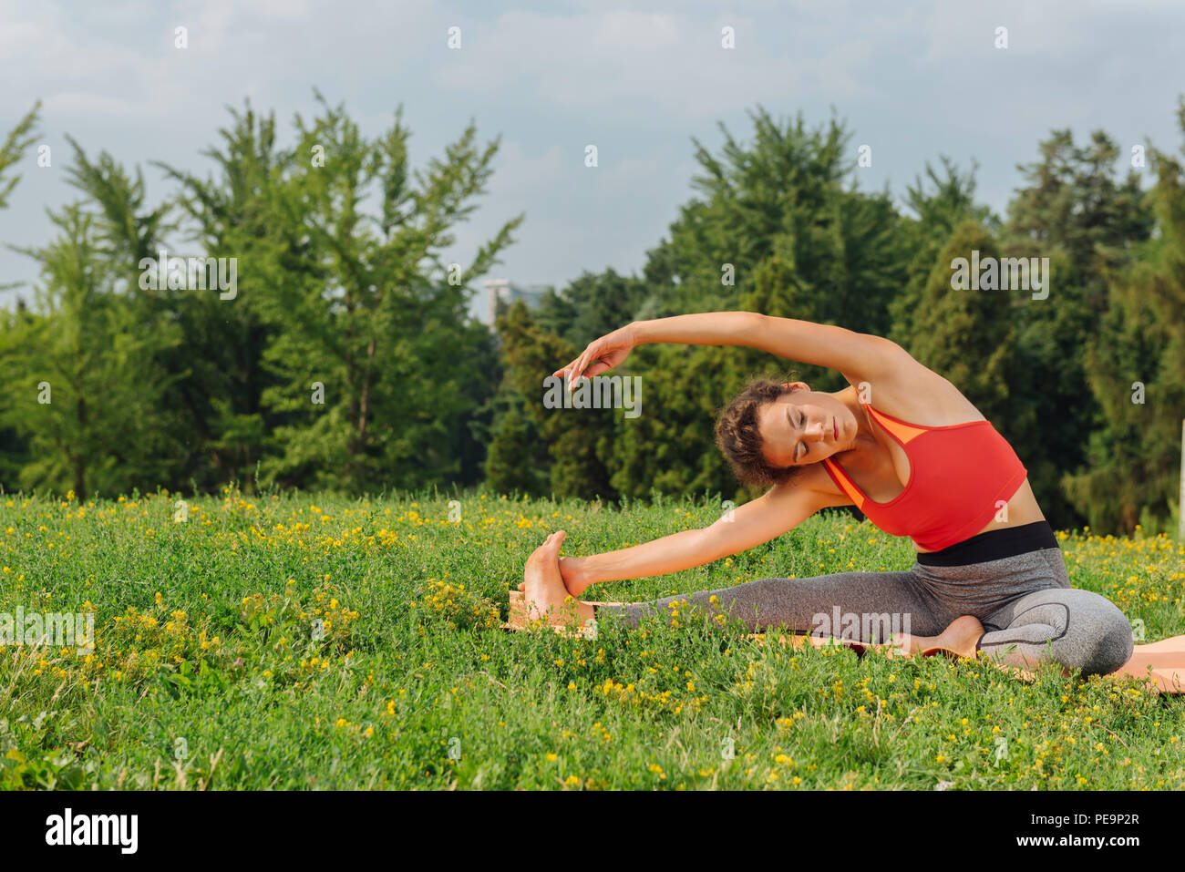 Schlanke Sportlerin Yoga für abs sitzen auf Matten Stockfoto
