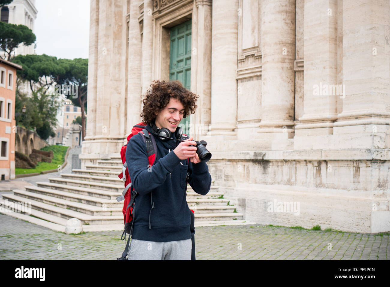 Hübscher junger Tourist Fotos nehmen. Backpacker mit seiner Kamera Stockfoto