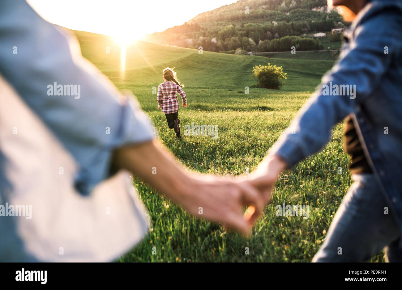 Ein kleines Mädchen mit ihrem älteren Großeltern Spaß in der freien Natur bei Sonnenuntergang. Stockfoto