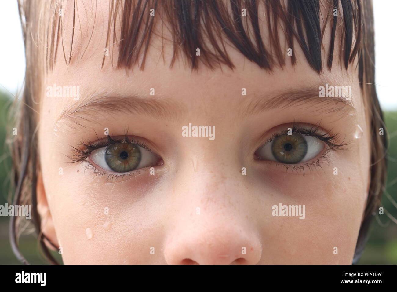 Nahaufnahme eines Kindes mit großen grünen Augen und eine intensive Angst Blick Stockfoto