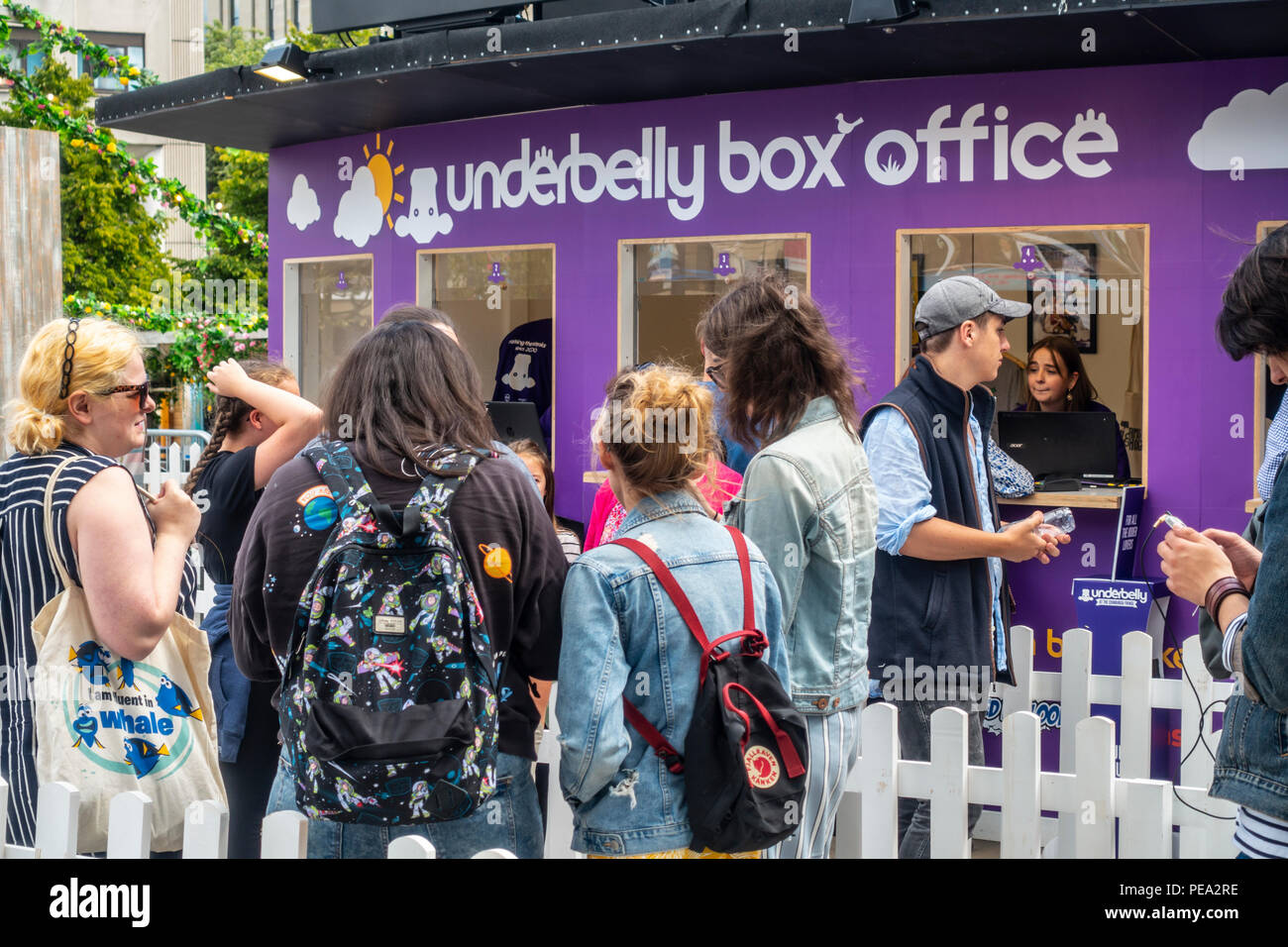 Besucher in Edinburgh Festival Fringe Queuing für Tickets an der Underbelly Box Office in Bristo Square im Zentrum der Stadt. Stockfoto