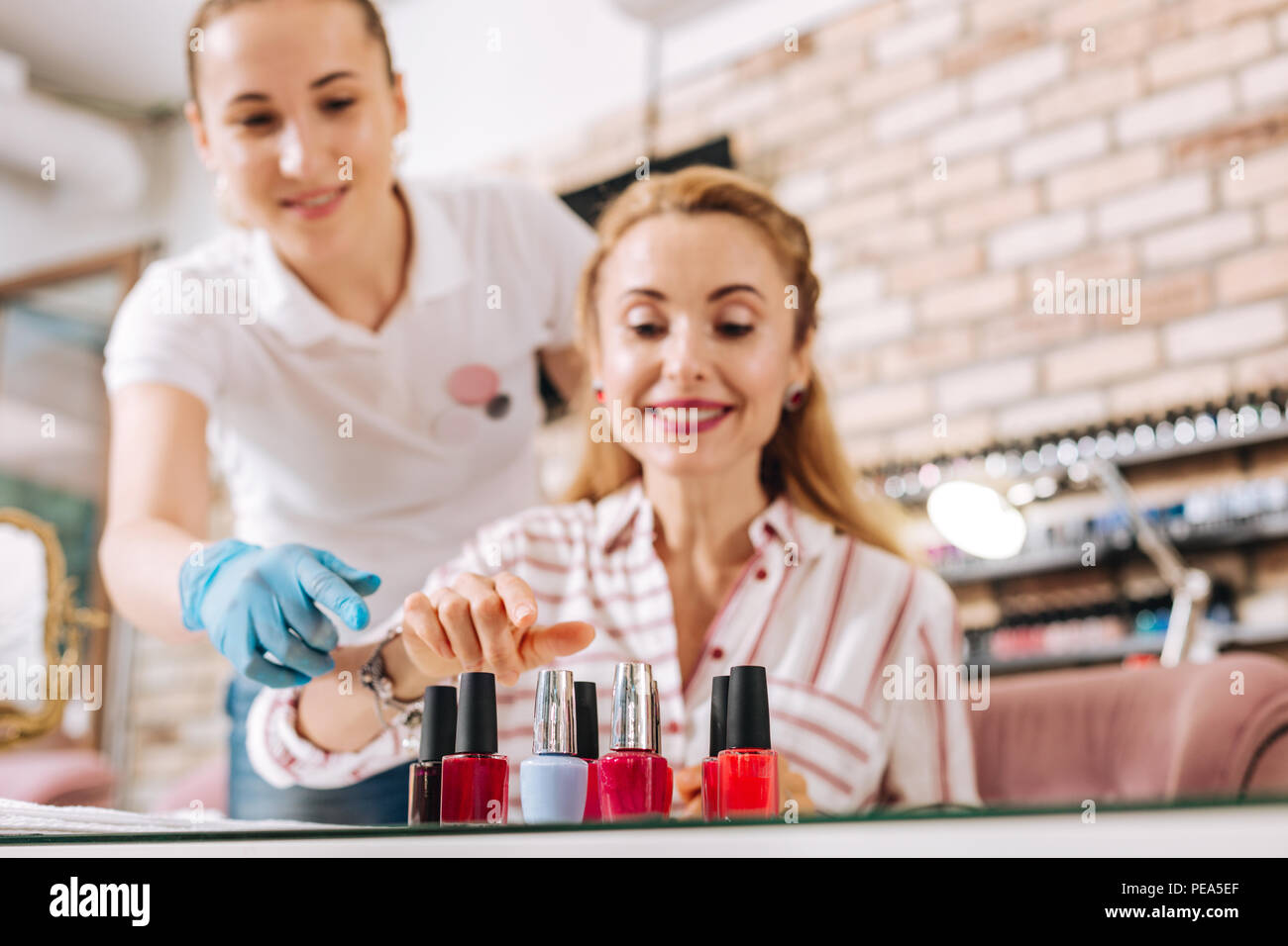 Positive reife Frau Stretching für Nagellack Stockfoto