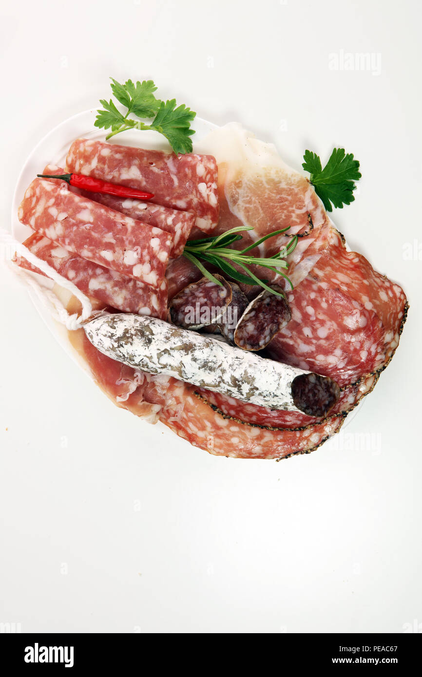 Essen Fach mit leckeren Salami, Coppa, frische Würste und Kräutern. Fleischplatte mit Auswahl. Stockfoto