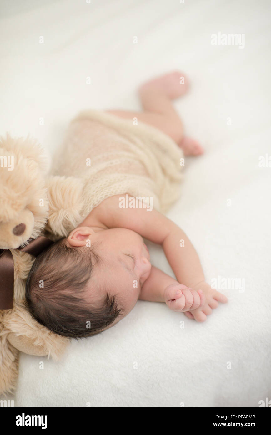 Cute Baby schläft auf einer Decke mit einem Spielzeug Teddybär - happy family Momente Stockfoto