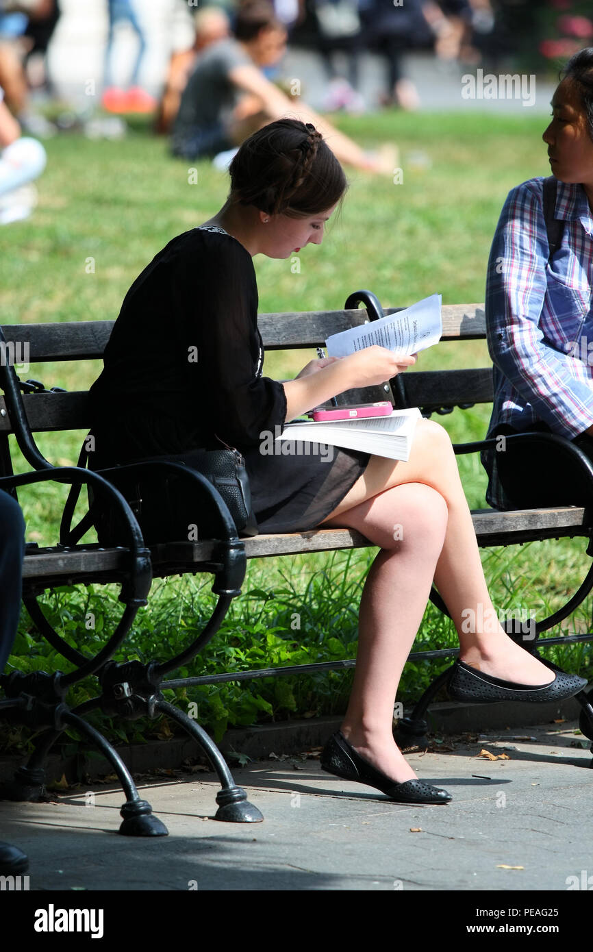 NEW YORK, NY - 05. SEPTEMBER: junge weiße Frau Studium ein Buch, während sitzen auf einer Bank in Washington Square Park, Manhattan am 5. September 2016 in N Stockfoto