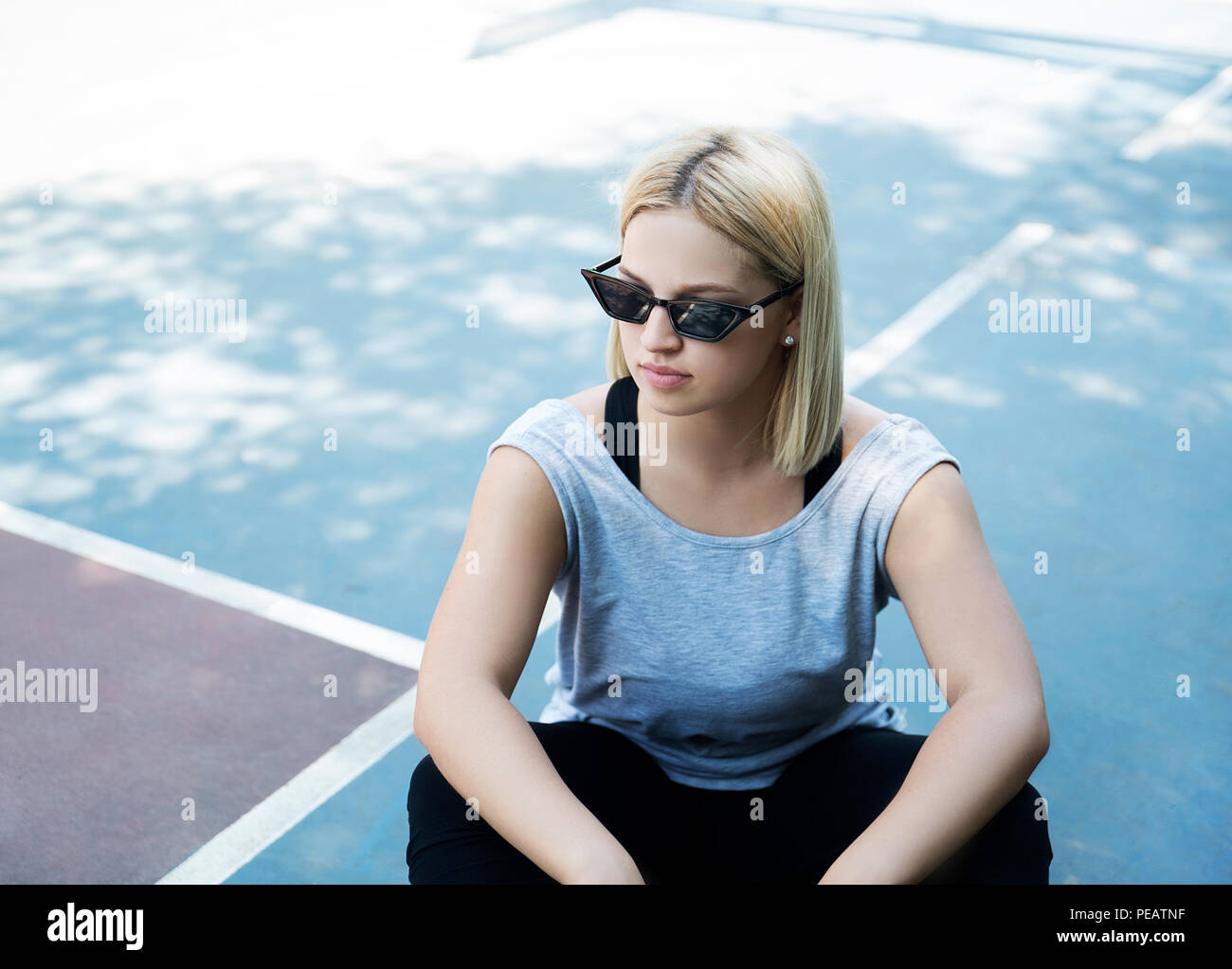 Junge Frau sitzt im Freien Stockfoto