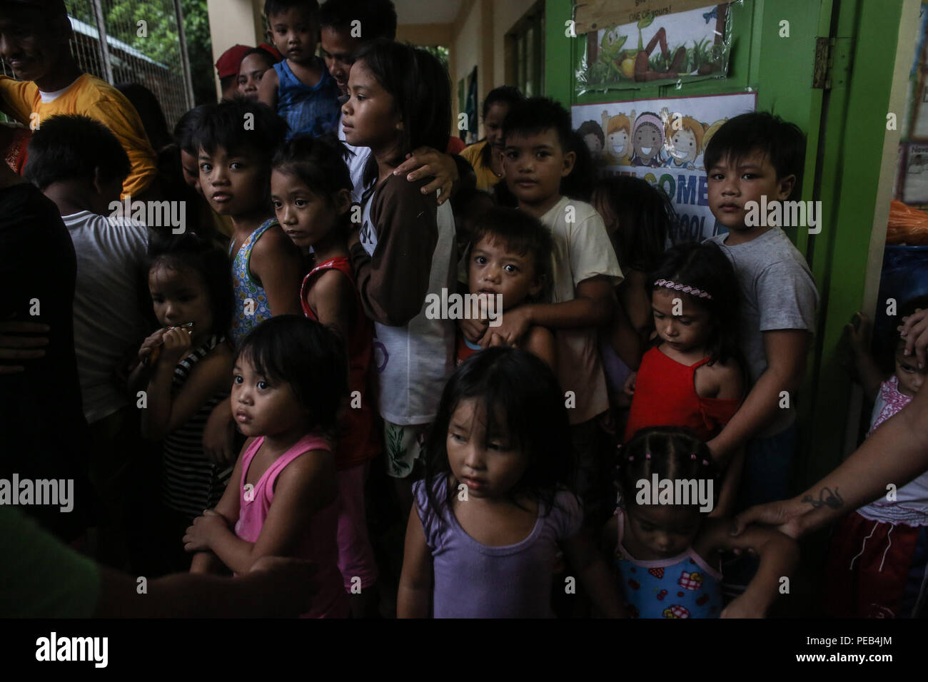 Manila, Philippinen. 13 Aug, 2018. Kinder fallen in der Linie während einer Hilfsaktion an einer Schule in einer Evakuierung Zentrum in der Stadt Navotas in Manila auf den Philippinen am Montag. August 13, 2018. Heftige Regenfälle und starke Winde, die durch den Südwest-monsun von tropischen Sturm Yagi Enhanced, Vertriebenen tausende von Menschen und viele Teile des U-Bahn unter Wasser über das Wochenende. Credit: Basilio Sepe/ZUMA Draht/Alamy leben Nachrichten Stockfoto