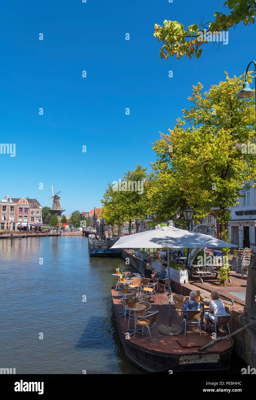 Schwimmende Cafe auf dem Oude Vest Kanal in Richtung Molen de Valk Windmühle, Beestenmarkt, Leiden, Zuid-Holland (Südholland), Niederlande suchen Stockfoto