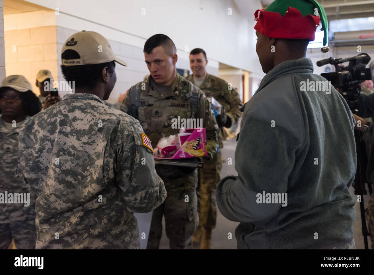 Staff Sgt. Micheal Tkachenko, mit der 65Th Military Police Company, 16 Military Police Brigade, gibt seinem Spielzeug zu einem der Elfen im Austausch für seine Lottery ticket für die 18. jährlichen Randy Oler Memorial Betrieb Spielzeug Fallen, bewirtet durch die US-Armee die zivilen Angelegenheiten & psychologische Operations Command (Airborne), Dez. 4, 2015, in der Papst Feld, N.C. Betrieb Spielzeug Drop ist der weltweit größte kombinierten Betrieb mit sieben Partner - nation Fallschirmjäger teilnehmenden und Soldaten erlaubt, die Möglichkeit, Kindern in Not zu helfen, überall Spielwaren für den Urlaub erhalten. Tkachencko, die im Toy eingetroffen Stockfoto