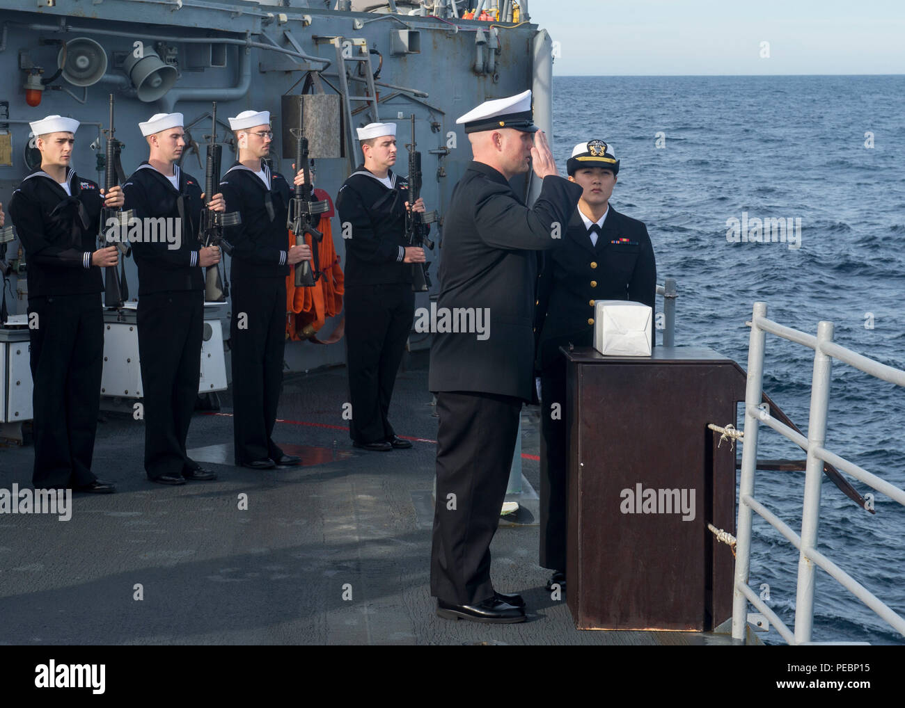 151206-N-GW 139-063 PAZIFISCHEN OZEAN (31. 6, 2015) - Chief Information Specialist Randy Smith begrüßt die Reste einer ehemaligen Marine Seemann an Bord der Arleigh-Burke-Klasse Lenkwaffen-kreuzer USS Princeton (CG-59) während einer Bestattung auf See Zeremonie. Marine Schiffe auf der ganzen Welt verhalten Bestattung auf See Zeremonien für die Familien der bleibt. (U.S. Marine Foto von Mass Communication Specialist 3. Klasse Eric Truhe/Freigegeben) Stockfoto