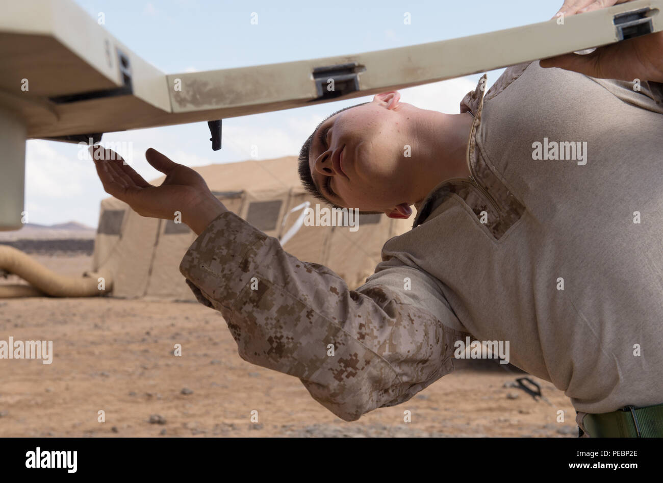 Ein U.S. Marine Corps Satellitenkommunikation Bediener zugeordnet nach Ostafrika Response Force, Combined Joint Task Force-Horn von Afrika (CJTF-HOA), montiert eine Satellitenschüssel während ein starker Punkt Verteidigung Training übung in Qaid, Dschibuti, Nov. 21, 2015. Durch gemeinsames Handeln mit US-amerikanischen und internationalen Partnern in Ostafrika, CJTF-HOA Sicherheit Kraft Hilfe führt, führt militärische Engagement, bietet Schutz und sorgt für die regionale gegen den gewalttätigen extremistischen Organisation Vorgänge aus, um die regionalen Anstrengungen ausgerichtet Unterstützung militärischer Unterstützung, regionaler Zugang und f sicherzustellen Stockfoto