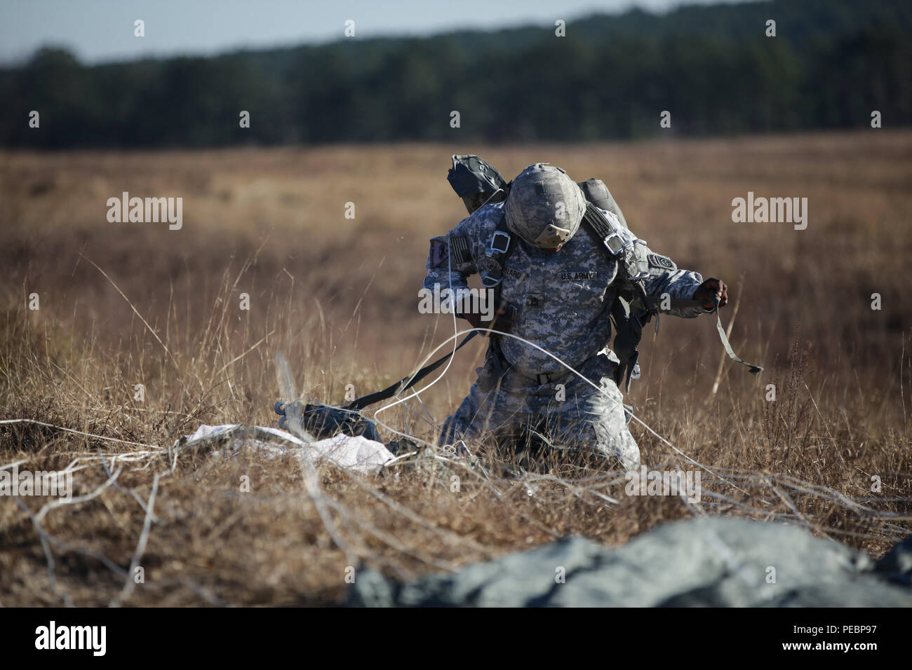 Us-Armee Fallschirmjäger Fallschirm Kabelbaum entfernt nach erfolgreichem Abschluss eine zerstreute springt auf Sizilien Drop Zone während des Betriebs Spielzeug Drop an Ft. Bragg, N.C., Dez. 4, 2015. Betrieb Spielzeug Drop ist der weltweit größte kombinierten Betrieb mit sieben Partner - nation Fallschirmjäger teilnehmenden und Soldaten erlaubt, die Möglichkeit, Kindern in Not zu helfen Spielwaren für den Urlaub erhalten. (U.S. Armee Foto von Pfc. Sharell Madden/Freigegeben) Stockfoto