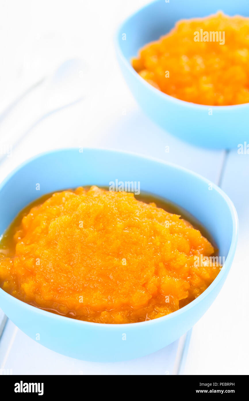 Frische hausgemachte vegan Kürbispüree oder Brei in blau Schalen, können als Baby oder Kleinkind essen, auf weißem Holz fotografiert (selektive Fokus) verwendet werden. Stockfoto
