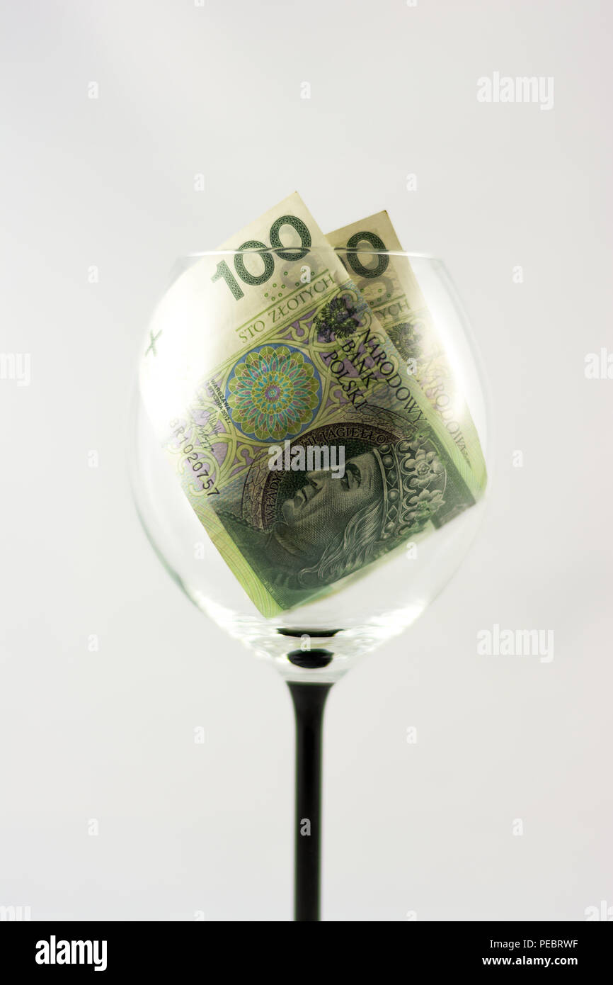 Zwei Banknoten hundert Zloty im Glas Wein Stockfoto