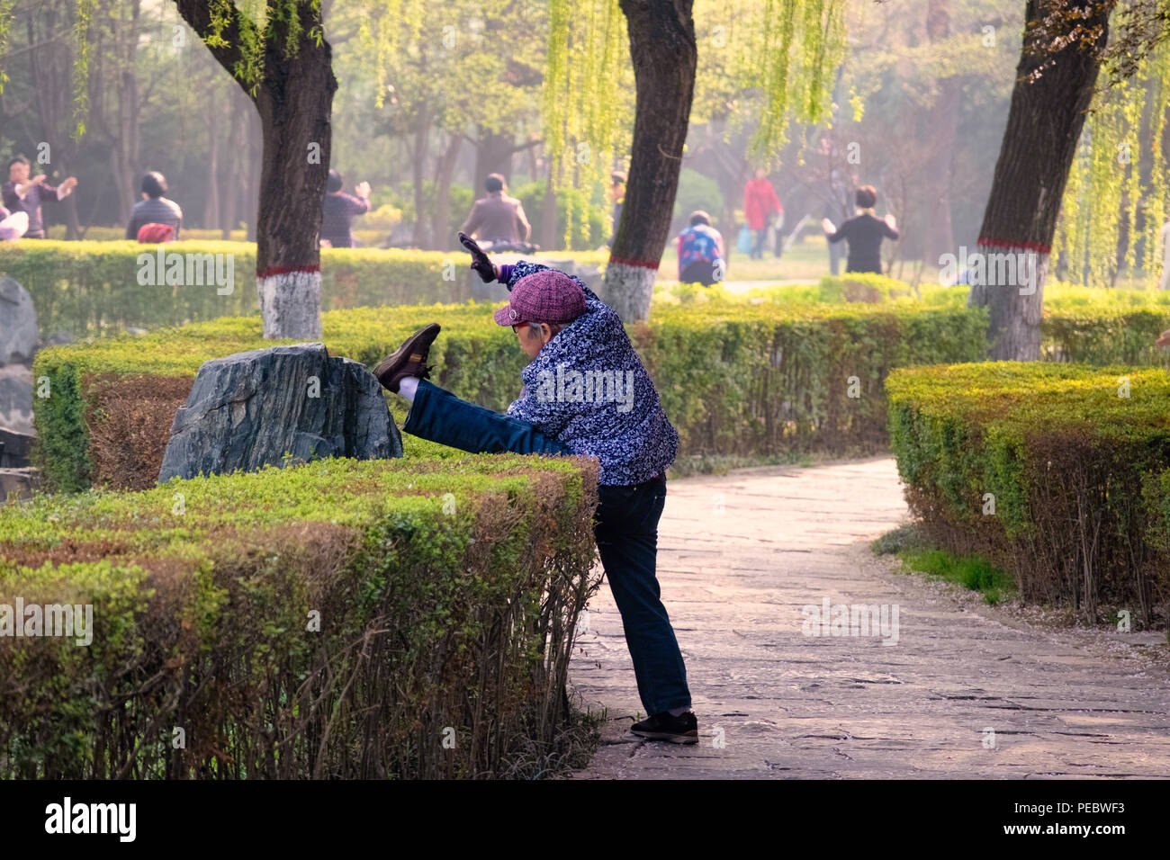 Ältere chinesische Frau Dehnen in den XinJinYuan Park, Xian, China Stockfoto
