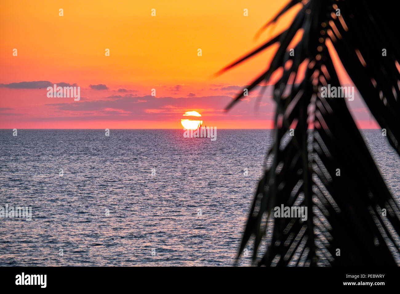 Segelboot durch die Scheibe der untergehenden Sonne, die Banderas Bucht, Jalisco, Mexiko. Stockfoto