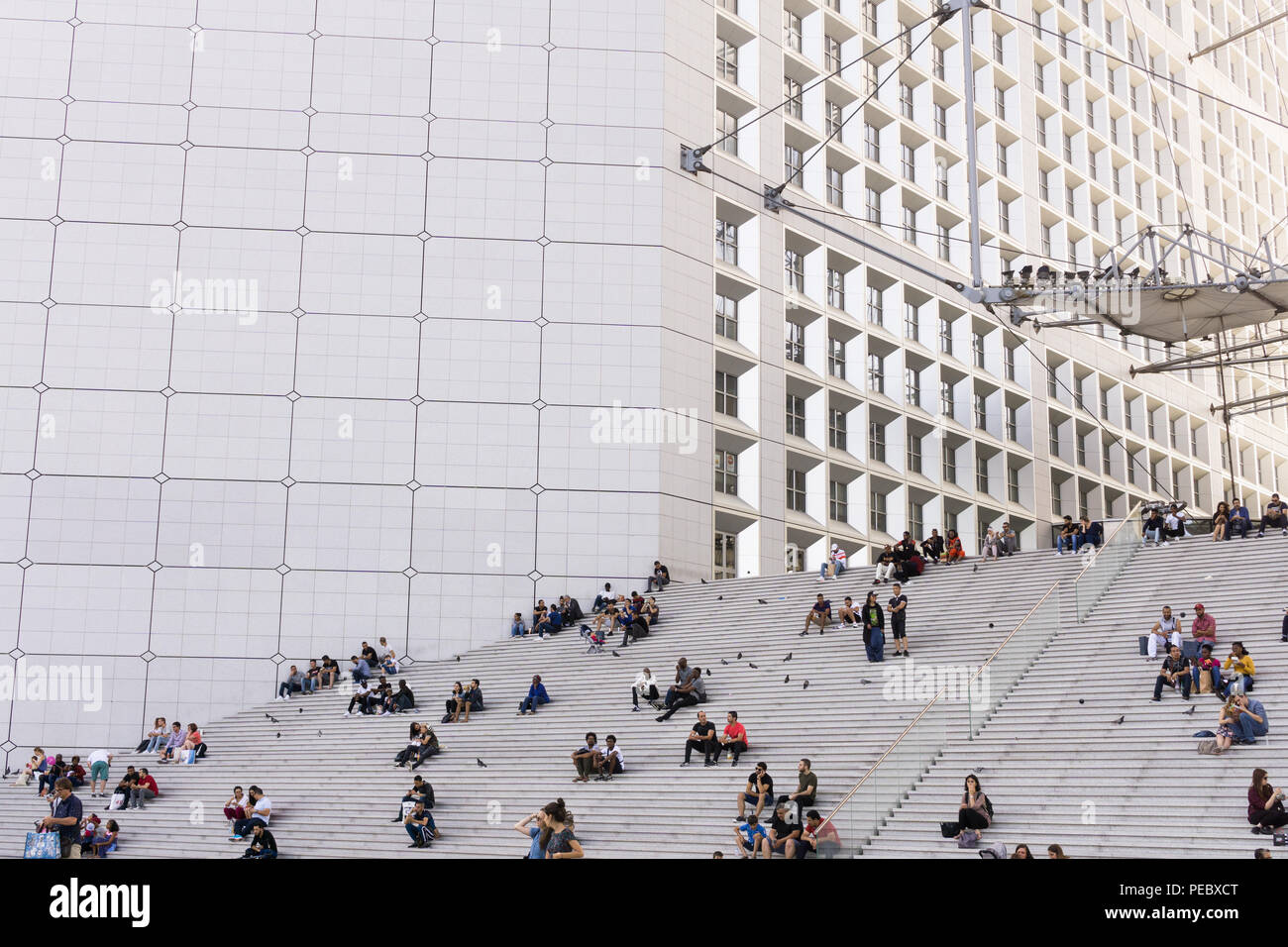 Menschen sitzen auf der Treppe von La Grande Arche in La Défense in Paris, Frankreich. Stockfoto