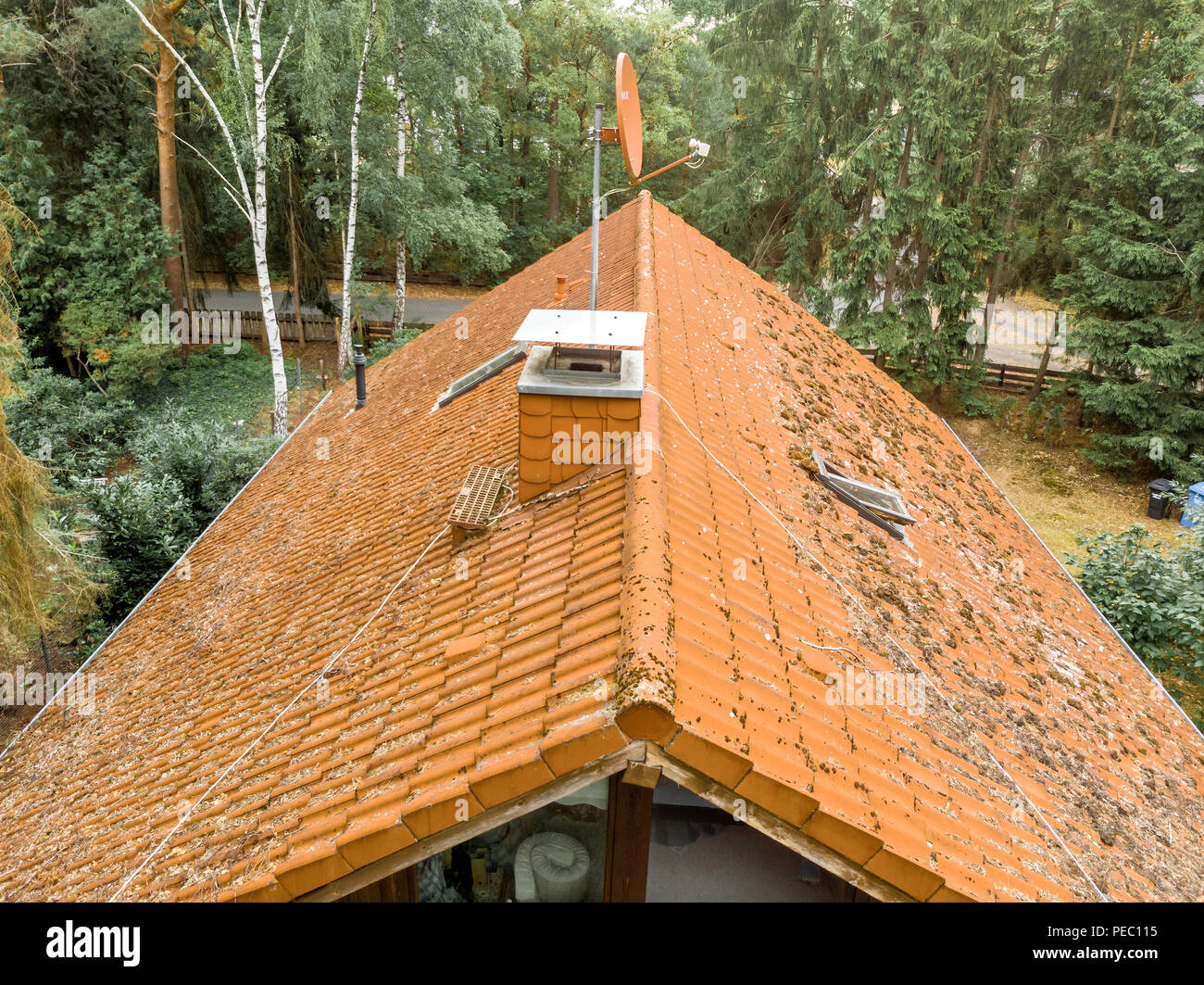 Prüfung der roten Ziegeldach ein freistehendes Haus, mit Kamin und Sat-Antenne Stockfoto